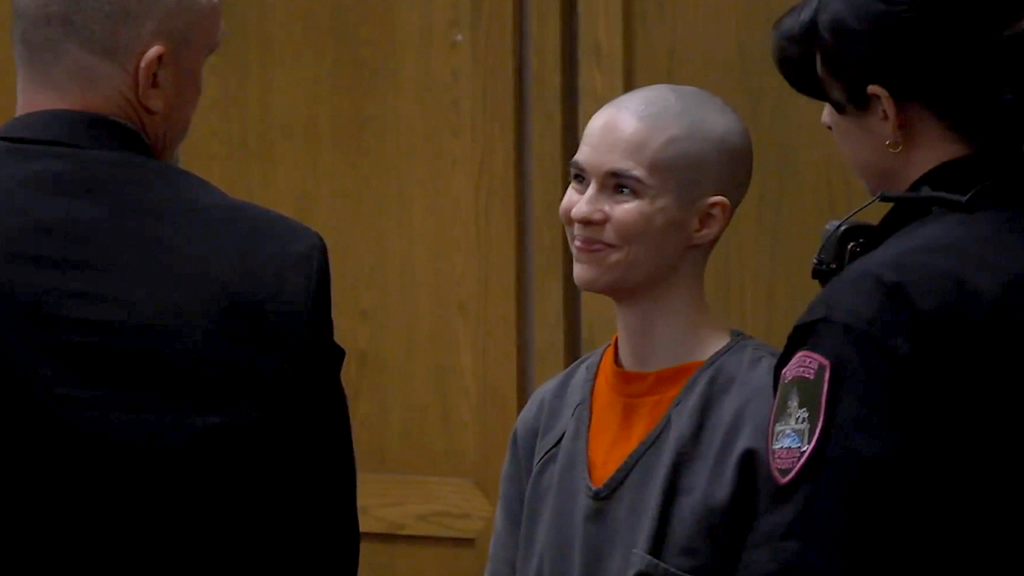 Woman who smiled in court gets 28 years for murdering her own father