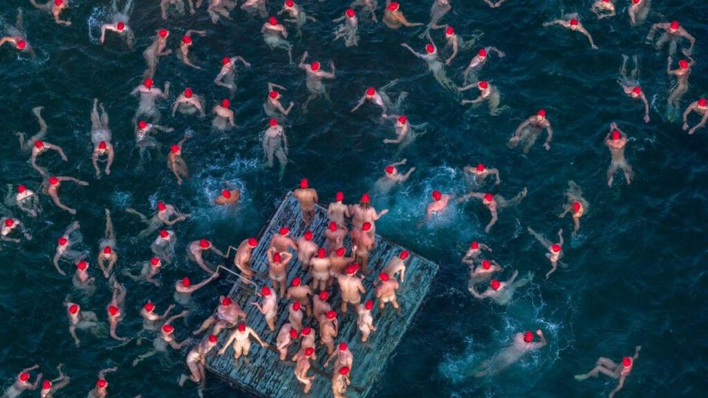 Thousands grin and bare it for swim at crack of dawn